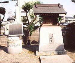お社と鉢かつぎ姫の形をした石像が説明看板を持っている写真