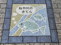 寝屋川の起点付近の歩道に埋め込まれた「ねや川のきてん」と書かれたサイン