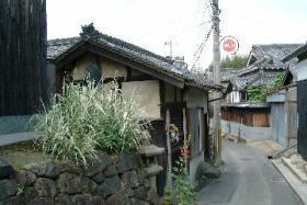 石積みで築いた基壇の上に置かれた小祠にある地蔵堂の写真