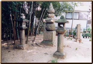 竹林の右横にある2つの石灯篭の間に高さ2.42メートルの五輪塔が建てられている伝・秦河勝の墓の写真