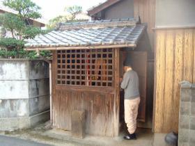 うぐいす地蔵(四條畷市)を拝む烏帽子を着用した男性の写真