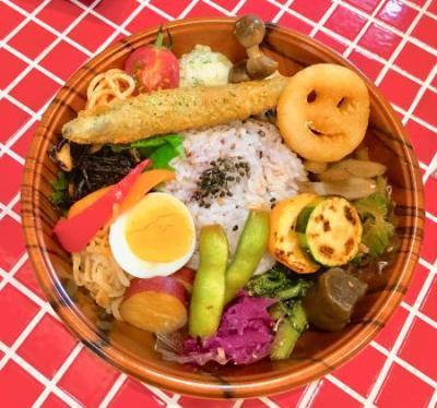 ご飯の周りにポテトや魚フライ、ミニトマトにゆで卵など色とりどりのおかずが入ったランチボウルの写真