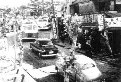 バス2台や自動車2台が同じ方向に走っている白黒写真