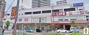全体が薄いピンク色をした外観のライフ香里園店の写真