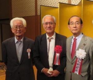 金屏風の前で年配の男性3名が並んで写っている写真