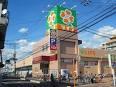 建物の上にオレンジ色の四葉のクローバーが描かれた緑色の大きな看板があるライフ寝屋川黒原店の外観写真