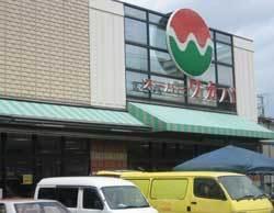 オレンジ色、白、緑の色が使われたロゴマークの看板が外壁に掲げてあるワカバ寝屋川店の外観写真