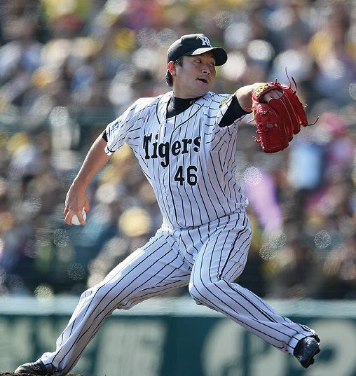 阪神タイガースのユニフォームを着て左手にグローブ、右手にボールを持って構えている鶴直人さんの写真