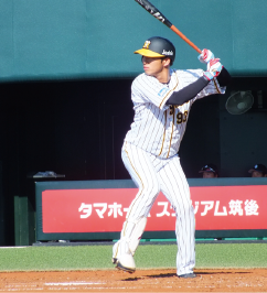 ユニフォームに身を包みバッターを手に打席に立っている西田直斗さんの写真