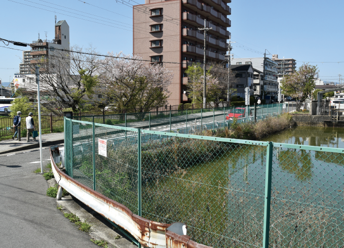 池の周りには柵が作られ、周りには高い建物が立ち並んでいる令和3年五藤池付近の写真