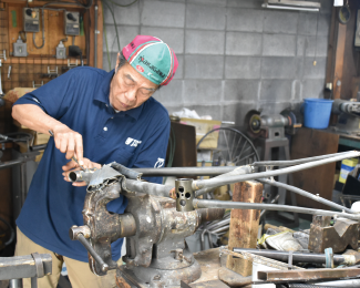 工房の作業台でフレームを磨く