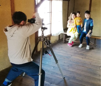 木造倉庫の会場でカメラに収まる家族