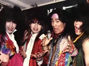色鮮やかな衣装を着てポーズをしている4名のバンドメンバーの写真