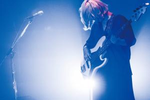 ベースを弾いている、ごっきんさんに青色のライトが当たっている写真