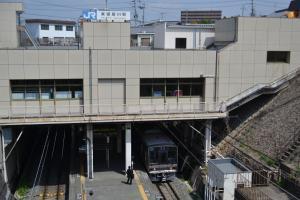 プラットホームに電車が停まり、ホームの上には駅舎の建物が建てられている写真