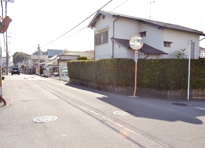 舗装された道路が通っており、右側には道路に沿って住宅が建てられている現在の写真