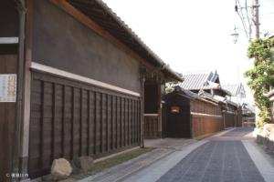 ブロックが敷かれ、きれいに舗装された道沿いに昔風の建物が立ち並んでいる写真