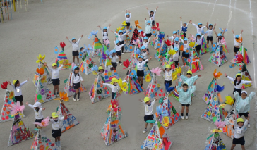 園庭で子供たちが両手を上げている画像