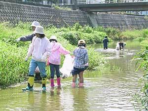 川に入って掃除をする子供たちの写真