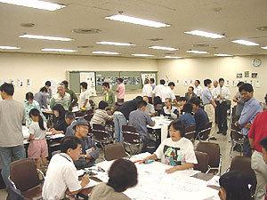 発表が終わり、席についたまま、または立ちあがって雑談をしている参加者たちの写真