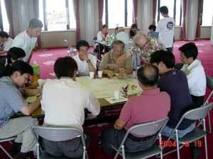 グループごとに分かれてテーブルに着き、話し合っている参加者たちの写真