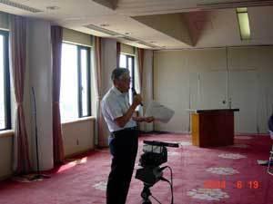 ワークショップの会場で、窓を背に話す白川さんを右側から撮影した写真