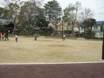 土の広場で遊ぶ人々の写真