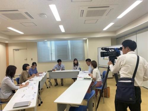 会議の様子をテレビカメラが入り取材が行われている写真
