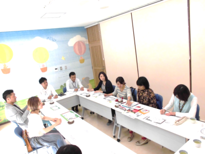 長机をロの字に並べてプロジェクトメンバーが会議を行っている写真