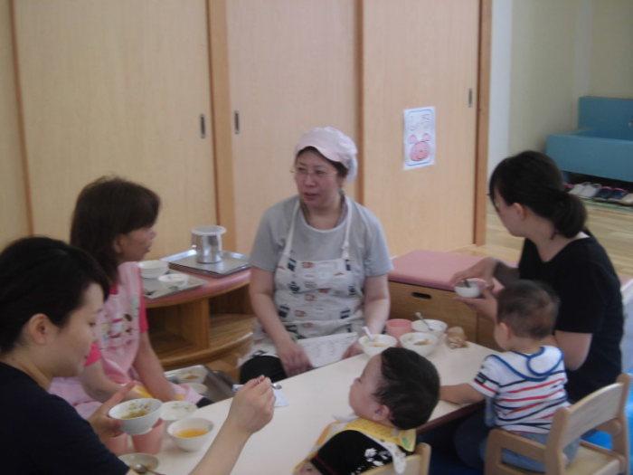 子供に離乳食を食べさせている二組の親子と2人の先生の写真