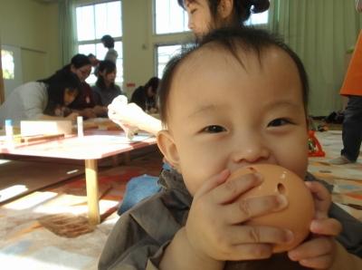 おもちゃを握って笑顔の赤ちゃんの写真