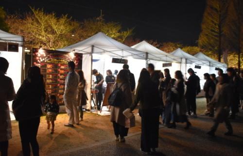 夜になっても出店されているテントの前に沢山のお客さんの行列ができ、賑わっている様子の写真