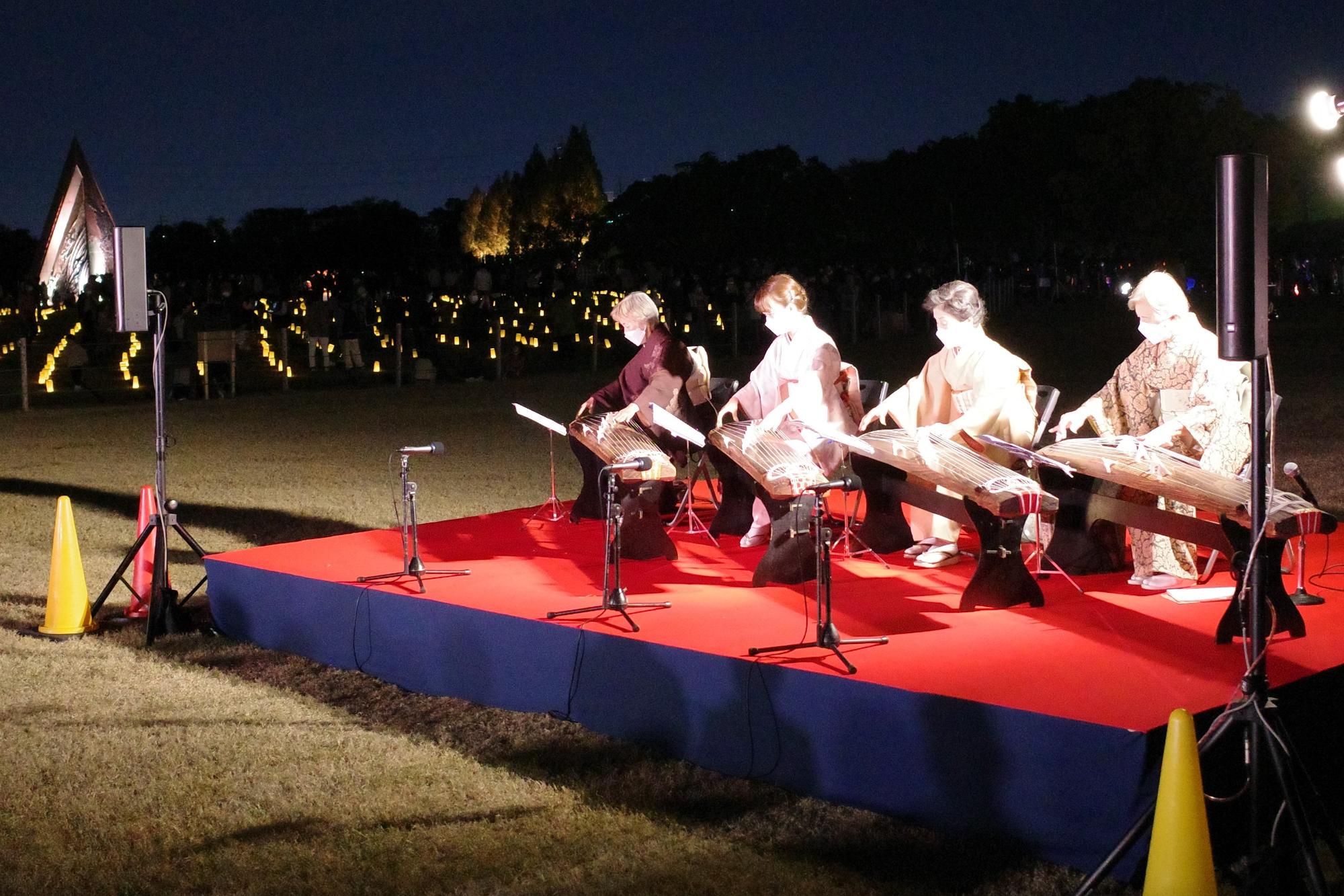 ランタンの広場を背景にステージでは琴の生演奏が行われています