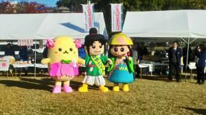 体がクリーム色で頭にピンク色のお花のようなものが着いているゆるキャラとねや丸くん、はちかづきちゃんが並んで写っている第37回寝屋川市農業まつりの写真