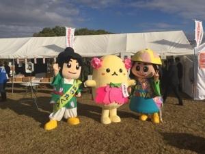 ねや丸くんと体がクリーム色で頭にピンク色のお花のようなものが着いているゆるキャラ、はちかづきちゃんが並んで写っている写真