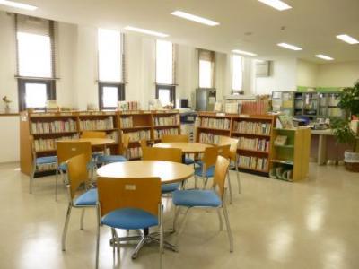 丸い机と椅子が設置されており、本棚には沢山の本が並んでいる写真