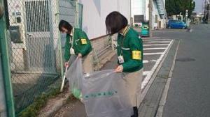 ゴミ袋とトングを持ったクロネコヤマトの社員二名が清掃活動をしている様子の写真