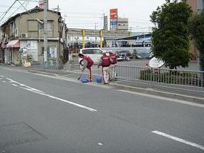 大阪トヨタLOGI＆B-TEC株式会社の社員の方たちが車道の端でごみを集めている様子の写真