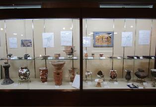 展示棚に土器・石器・金属器・木製品等の考古資料が展示されている写真