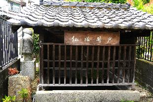 祠のような形をした湯屋が谷弘法井戸の写真