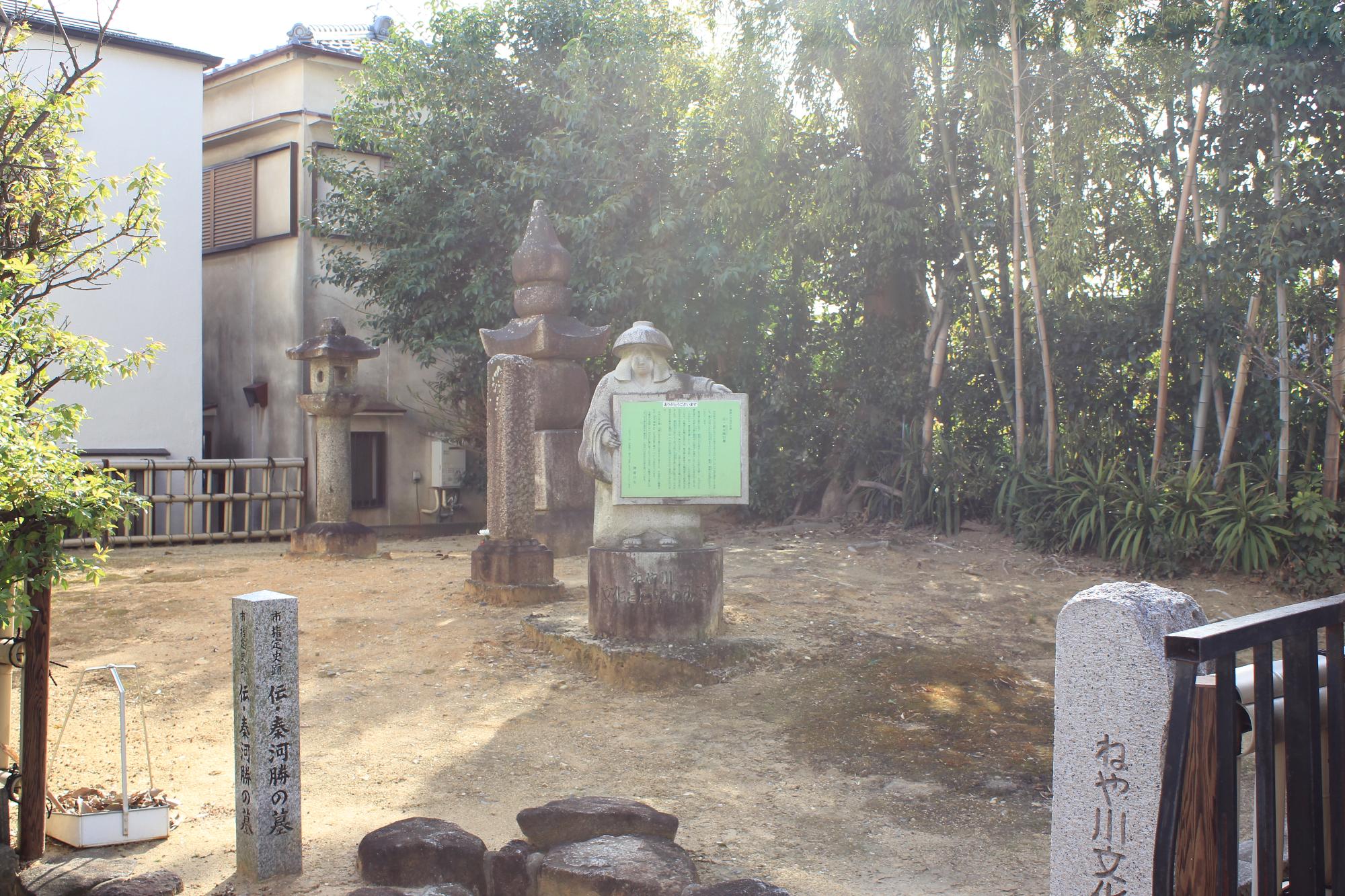 五輪塔の前にたつ鉢かづき像