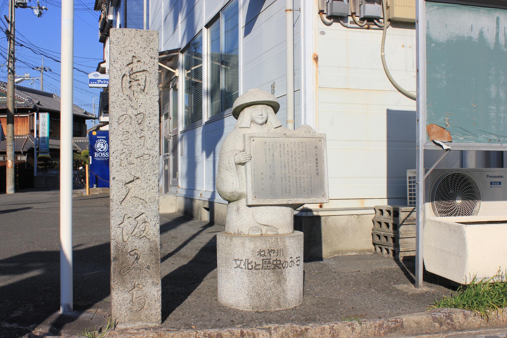 四辻に立っている石碑と鉢かづき像
