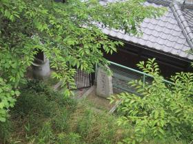入口に石碑があり、柵で囲いがしてある屋根付きの弘法井戸(田井)の写真