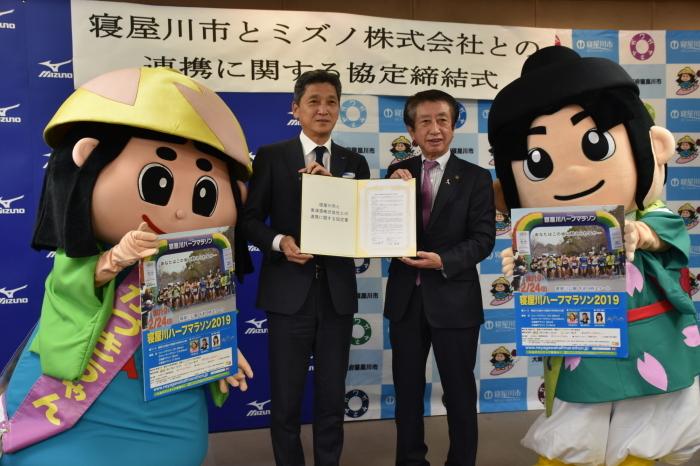 ミズノ株式会社様と協定書を手に記念撮影している写真