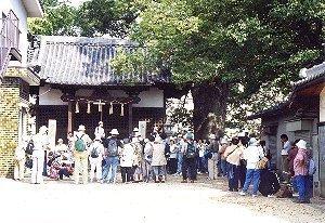 神社の鶯地蔵を拝む人々の写真