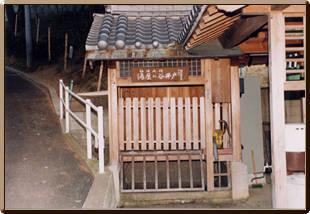 祠のような形をした湯屋が谷弘法井戸の写真
