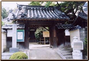 瓦屋根のついた門の奥に本堂が見える西蓮寺の写真