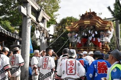 だんじりが到着した高宮神社の鳥居前に法被姿の人々が集まっている写真