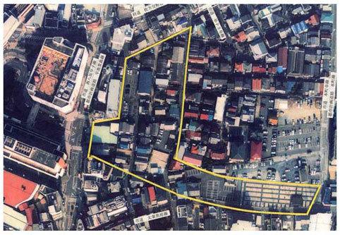 一部が黄色い枠で囲んである、建物が沢山立ち並んでいる市街地を上空から写した写真