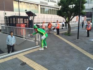 寝屋川駅前でオレンジ色のベストを着た人や緑色の服装をした人が啓発活動を行っている写真